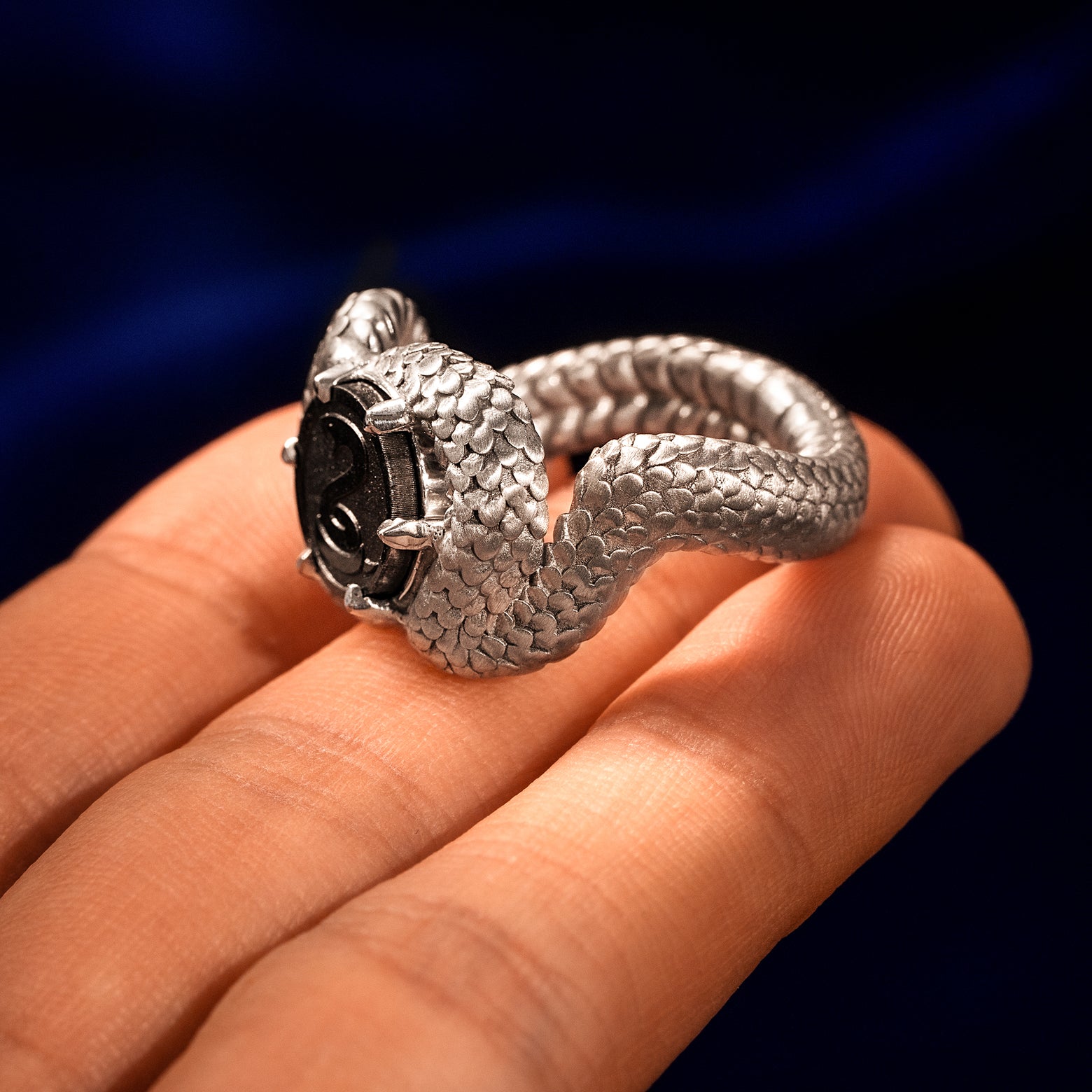 Sterling silver snake shaped statement ring balancing on a models fingertips