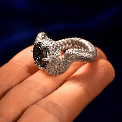 Sterling silver snake shaped statement ring balancing on a models fingertips