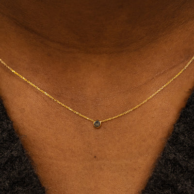 Close up view of a model neck wearing a 14k yellow gold Bezel set Smoky Quartz gemstone necklace 