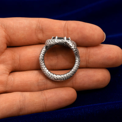 A model holding a 925 sterling silver engraved black diamond snake ring flat to show the thickness of the band