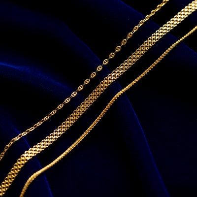 Flat Mariner chain, Bismark Chain, and Mini Franco Chain on a dark blue cloth background