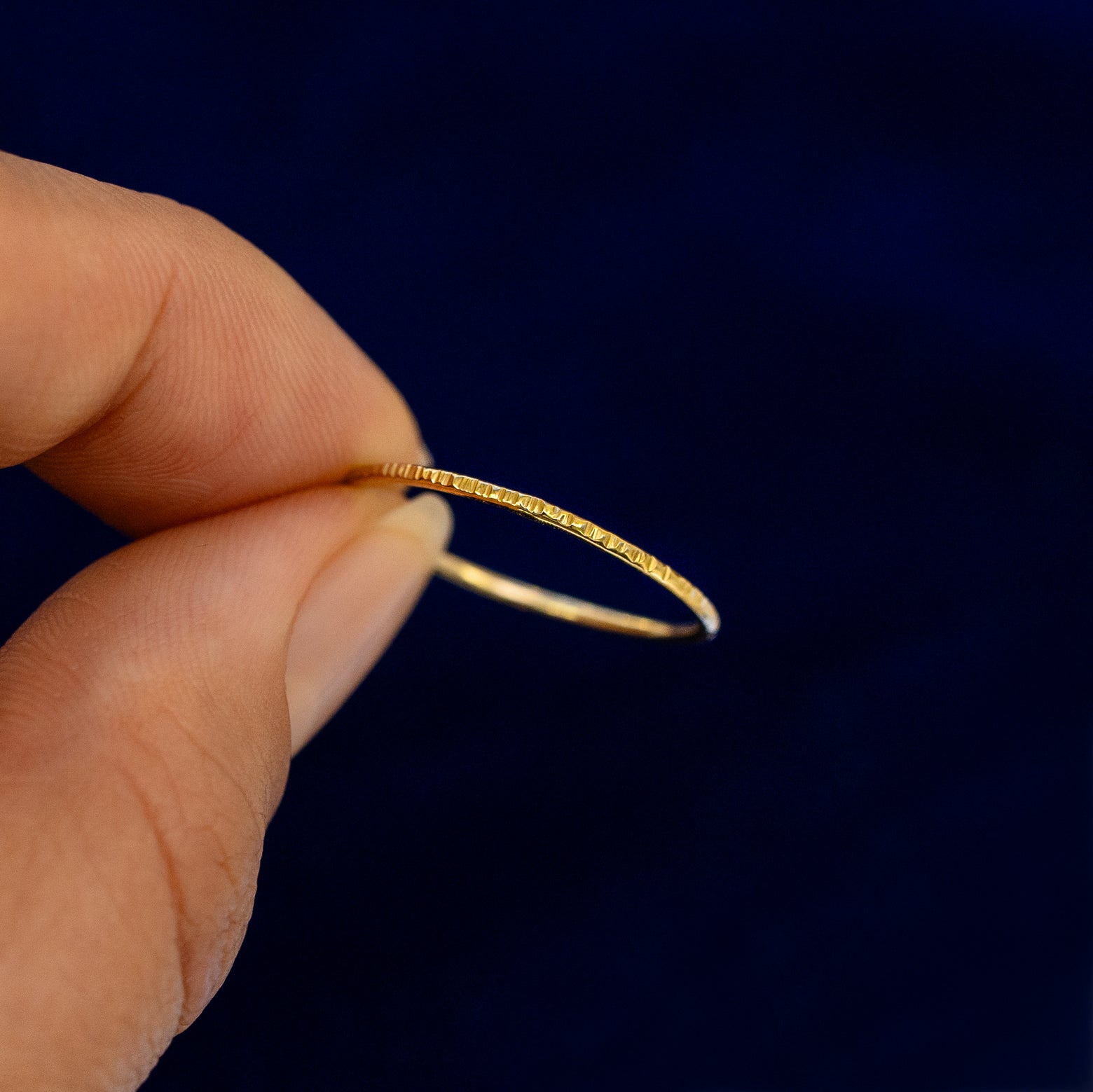 A model holding a Shimmer Ring tilted to show the side of the ring