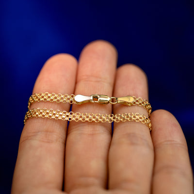 A yellow gold Bismarck Chain Bracelet wrapped around a model's fingers to show the chain and the lobster claw clasp