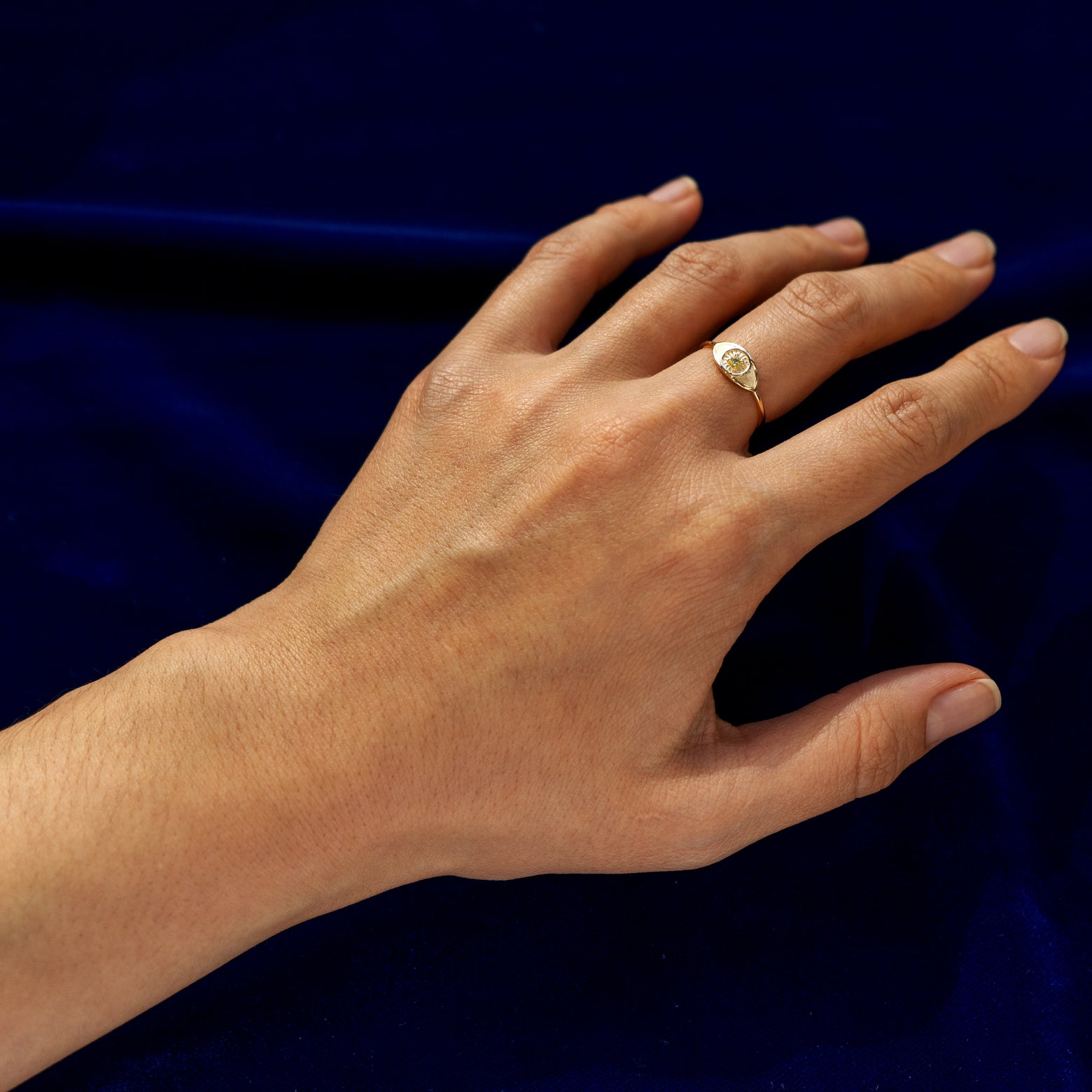 Full view of a Ruby Gemstone Evil Eye Ring on a model's finger