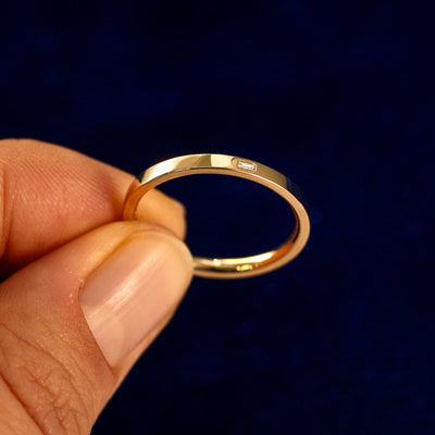 A model holding a Flush Set Baguette Diamond Ring tilted to show the details of the ring