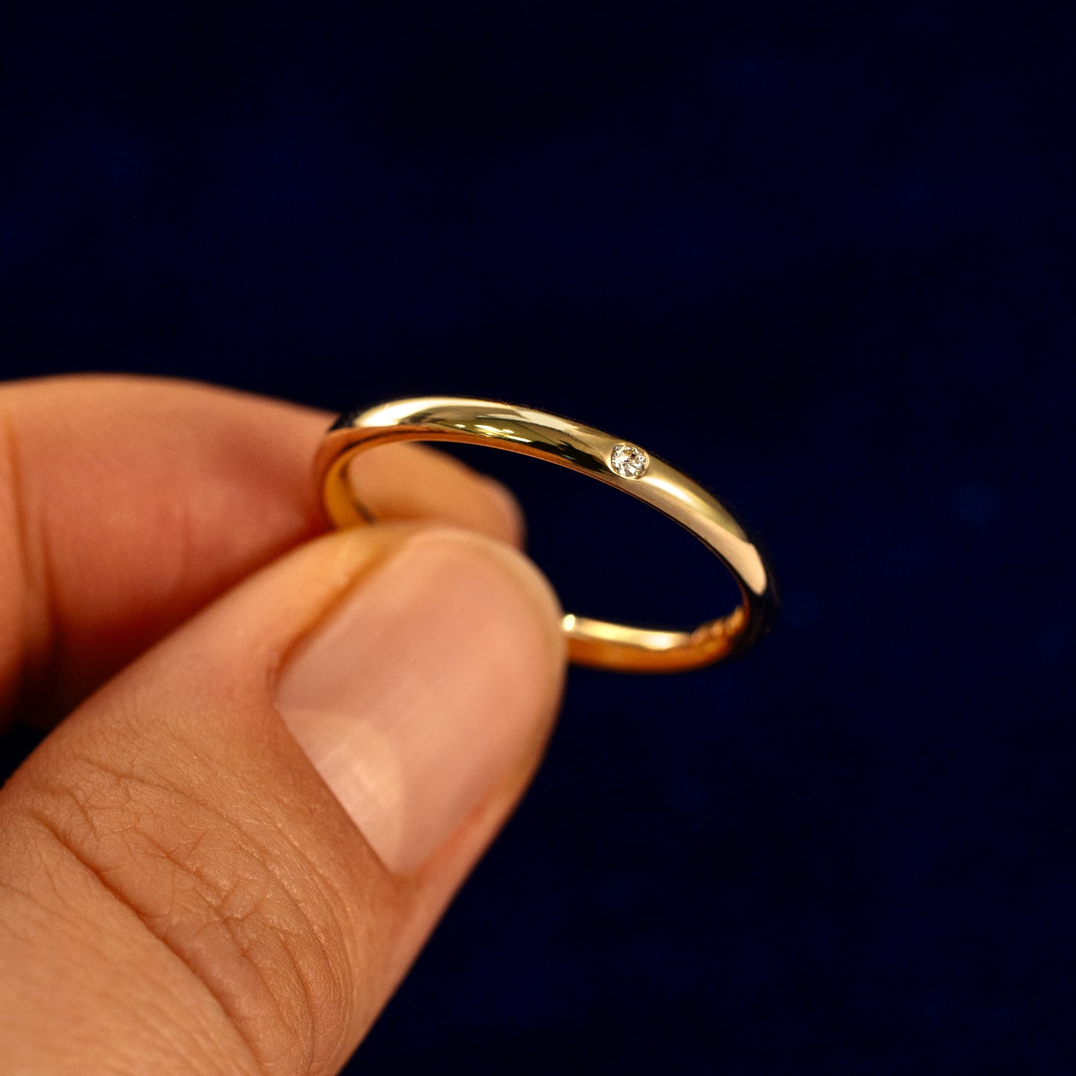 A model holding a Flush Set Round Diamond Ring tilted to show the details of the ring