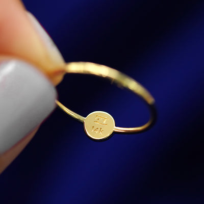 A model holding a star disk ring to show the AU and 14k stamps on the inside of the disk