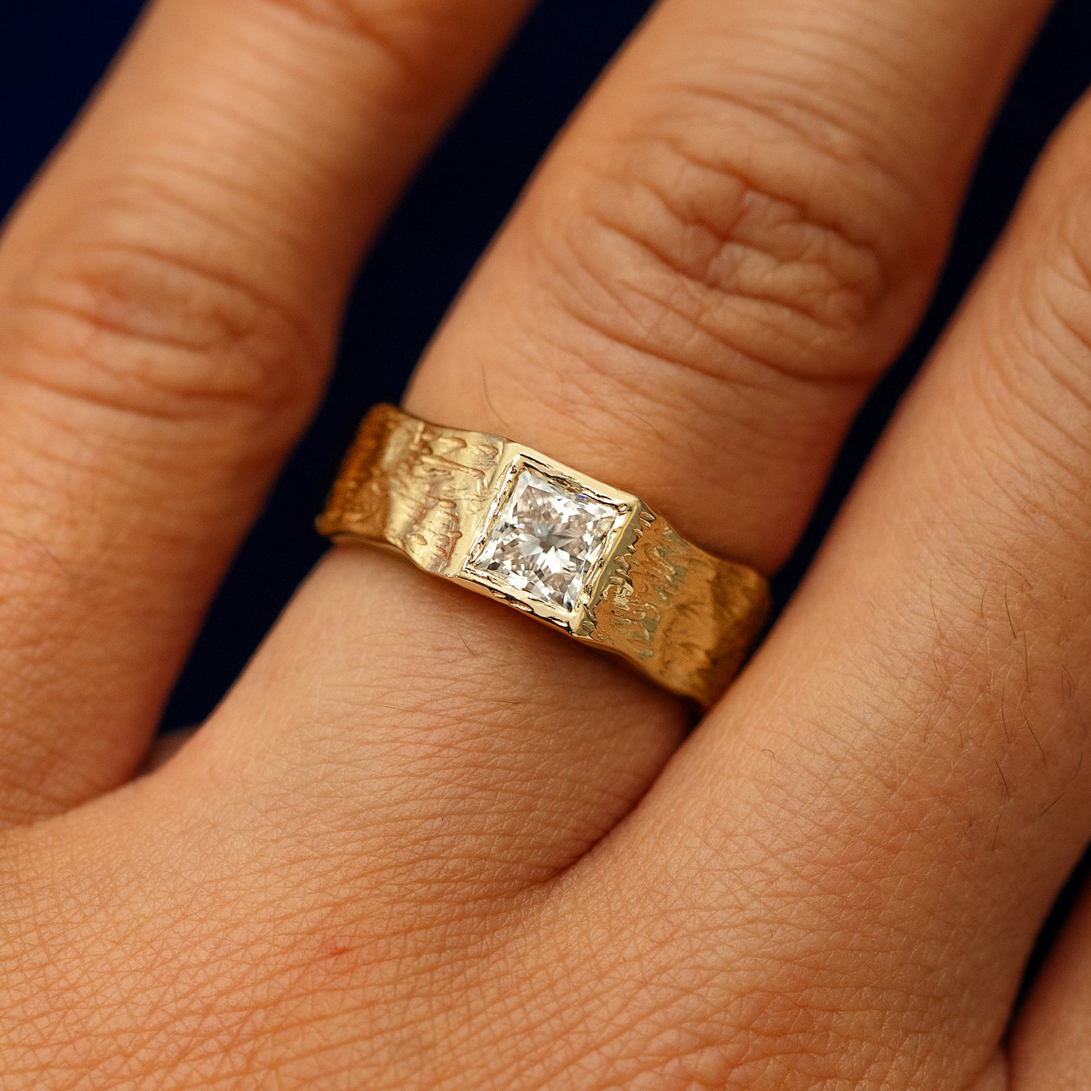 A princess cut lab diamond organic band on a models finger