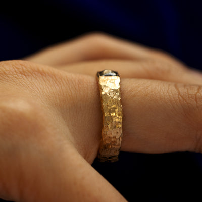 Side view of a square diamond organic band on a models finger to show the details of the finish