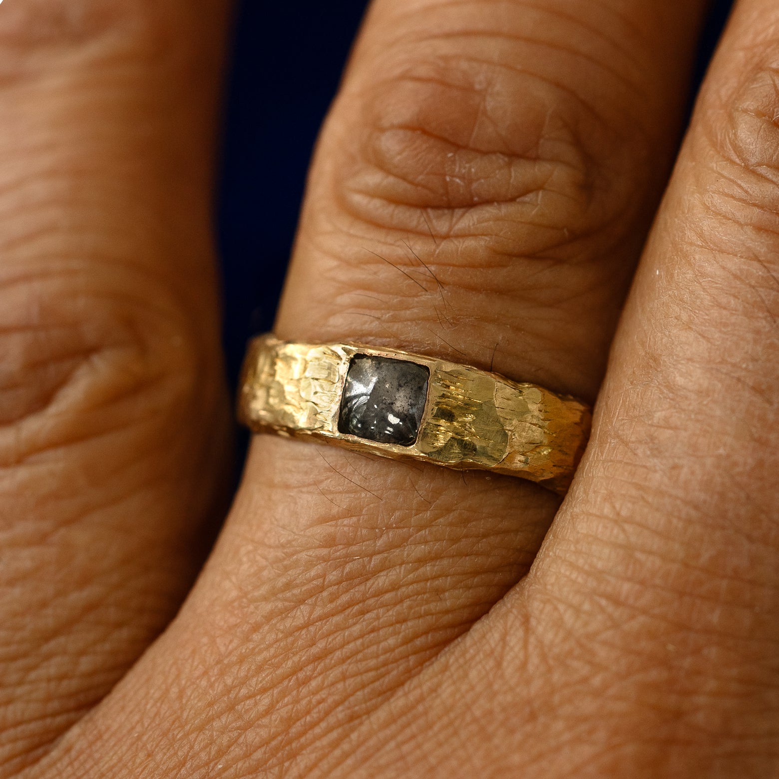A square salt and pepper cabochon diamond organic band on a models finger