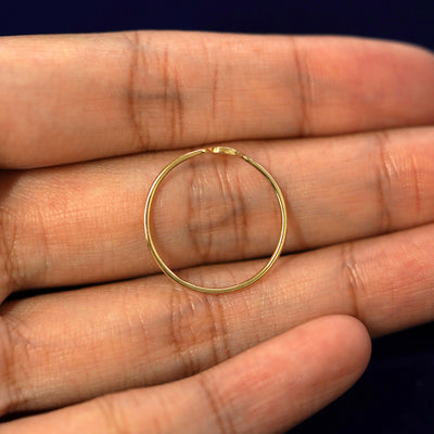A model holding a solid gold star disk ring in their hand to show the thickness of the band