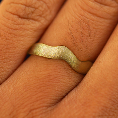 Close up view of a model's fingers wearing a 14k Stardust Liquid Band