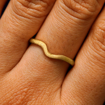 Close up view of a model's hand wearing a stardust thin liquid band