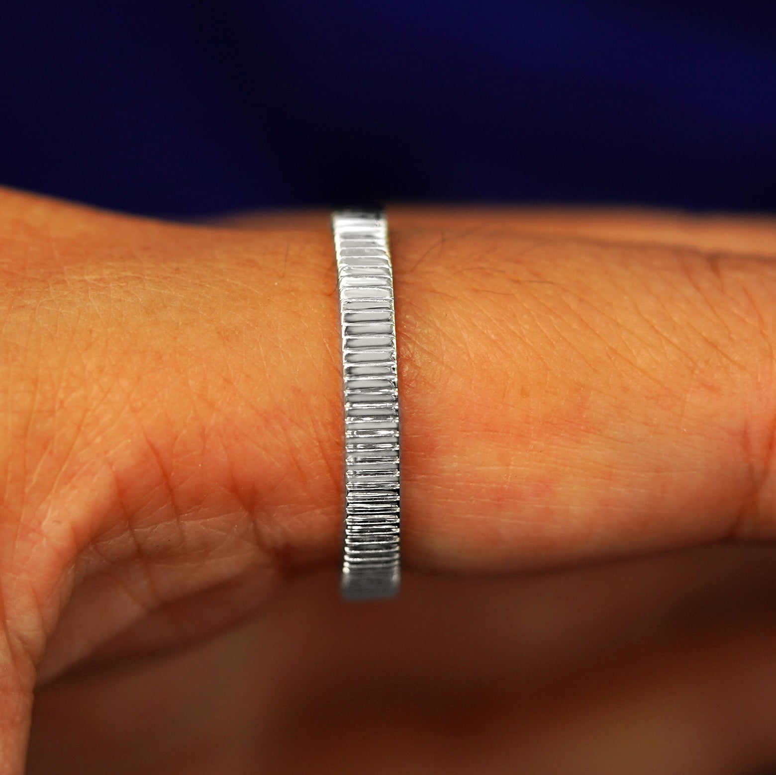 Side view of a 925 sterling silver Edge Band on a model's finger