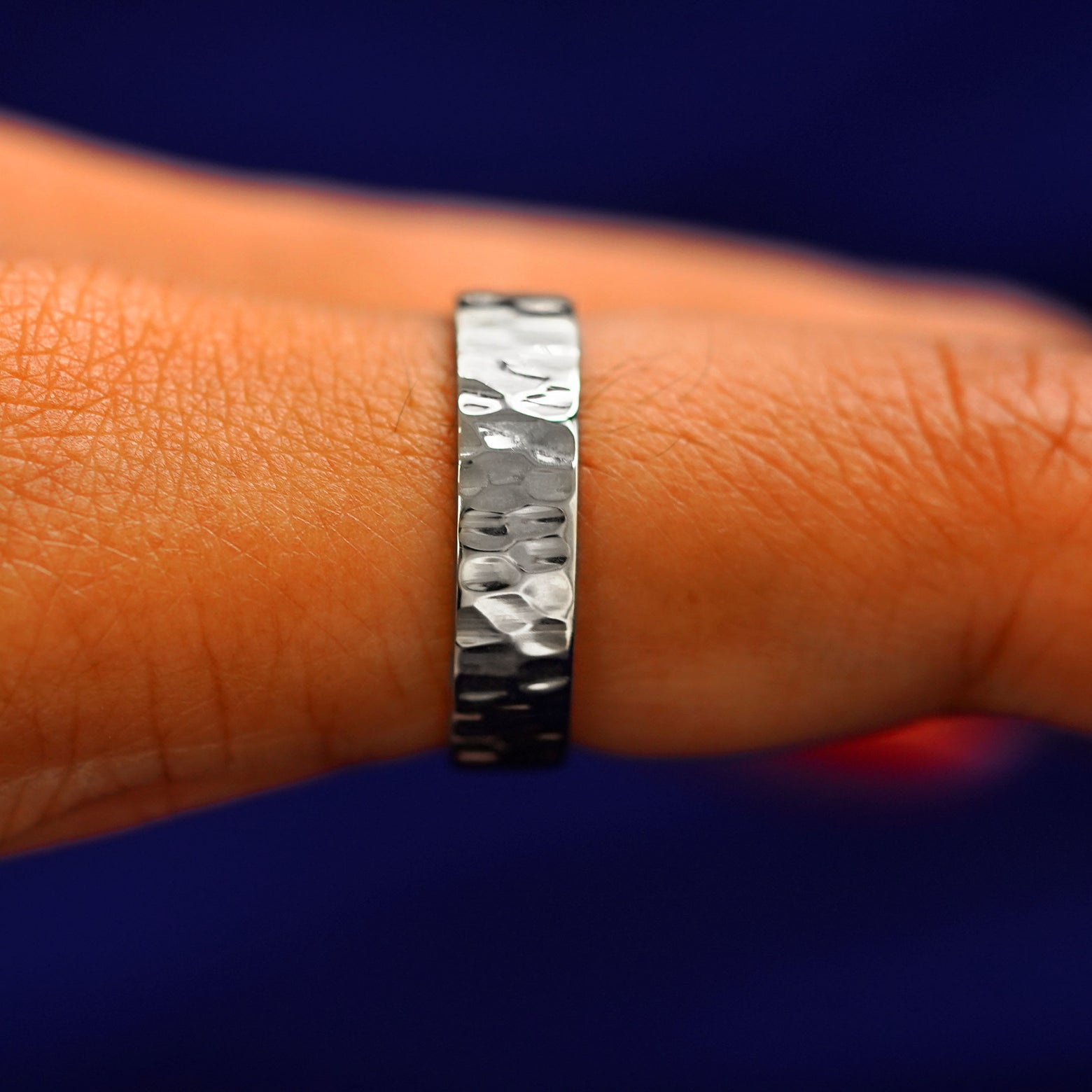 Side view of a Silver Industrial Hammered Band on a model's finger