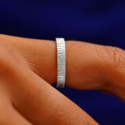 Side view of a Silver Industrial Wood Band on a model's finger