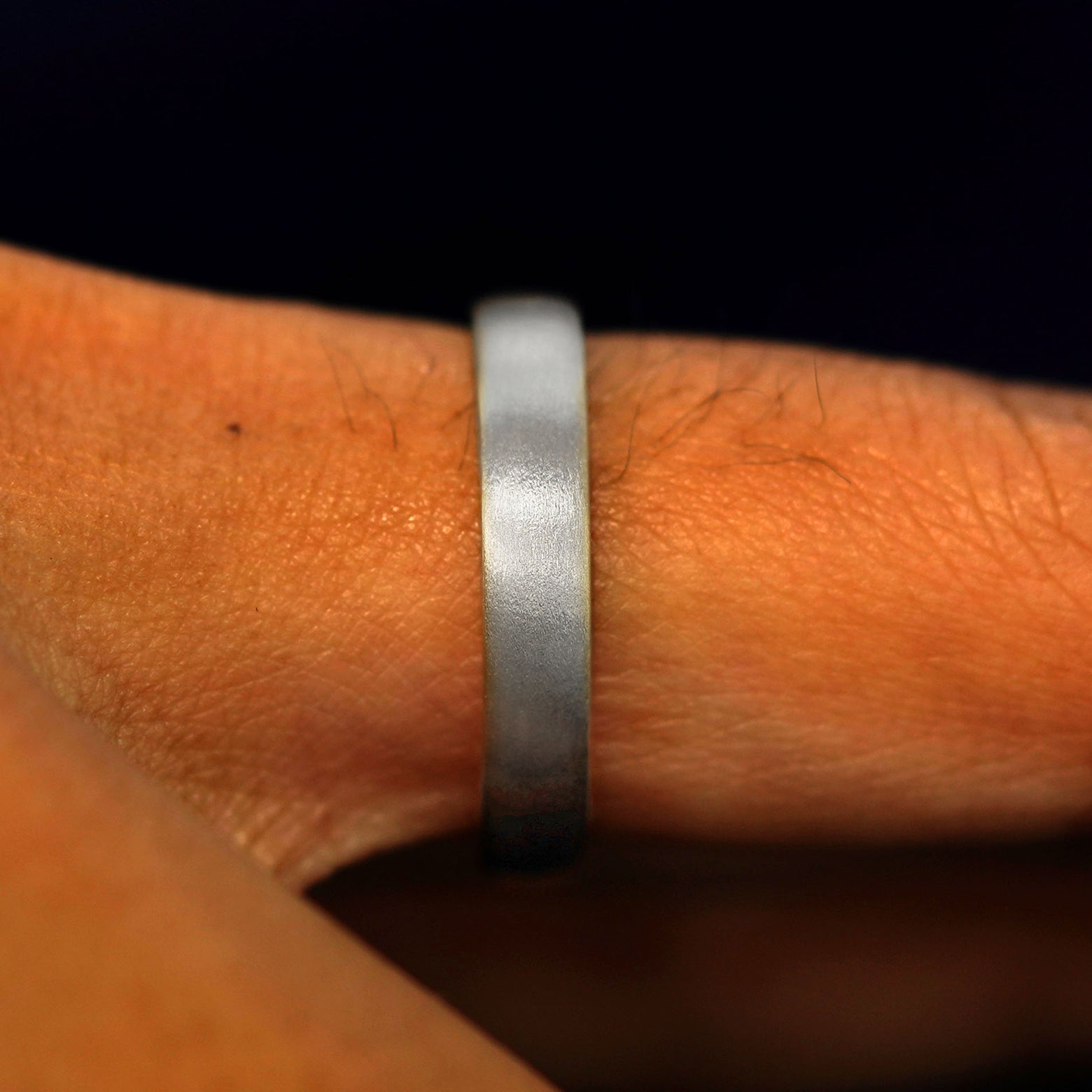 Side view of a solid 925 Silver Mix Matte Band on a model's finger