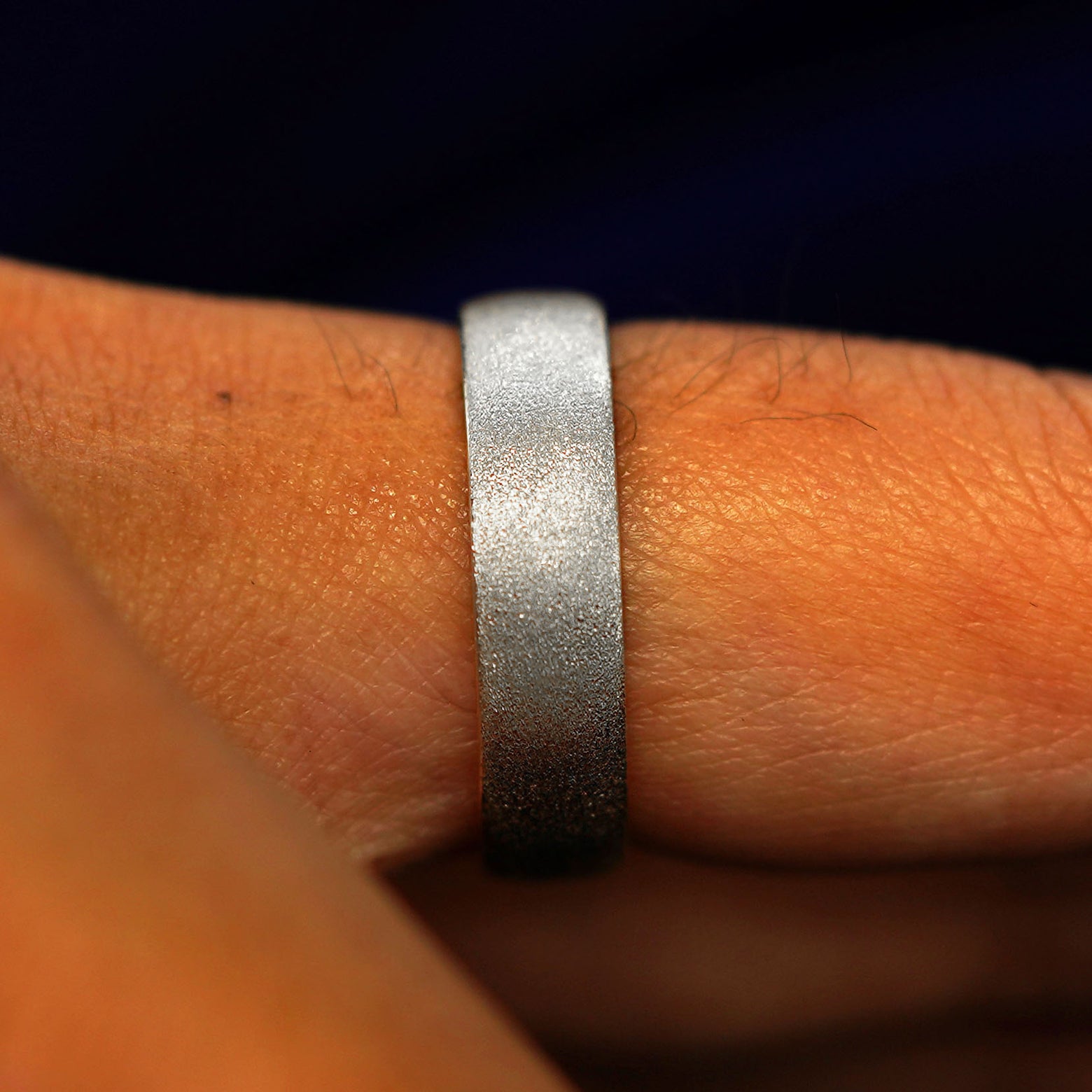 Side view of a solid 925 Silver Mix Stardust Band on a model's finger