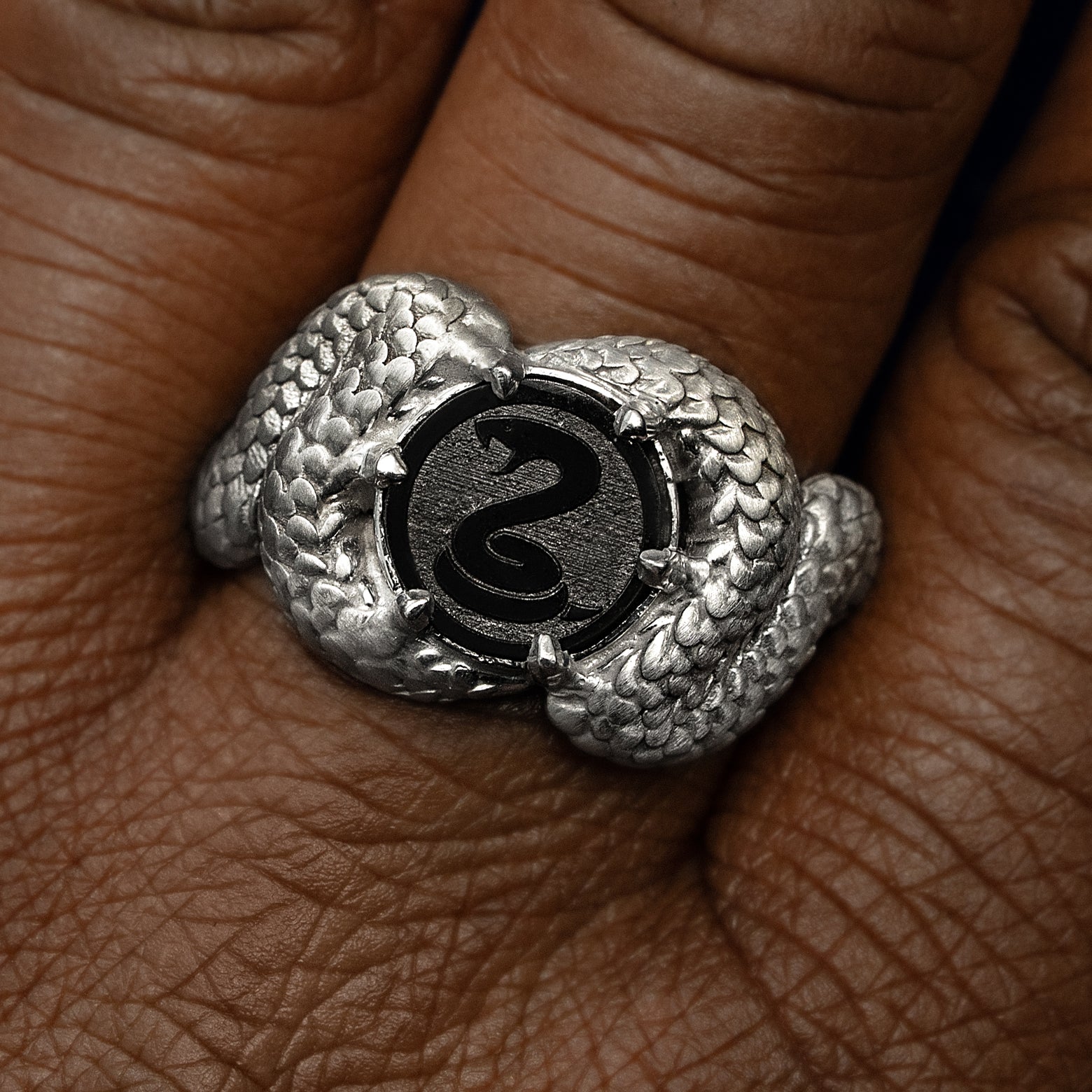Close up view of a model's fingers wearing a gothic style 925 Sterling Silver Engraved Diamond Snake Ring