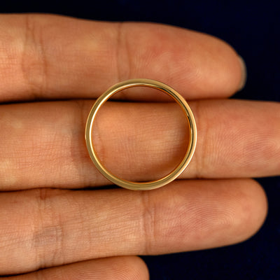 A Industrial Sun Moon and Stars Band lying flat in a models hand to show the thickness of the Ring