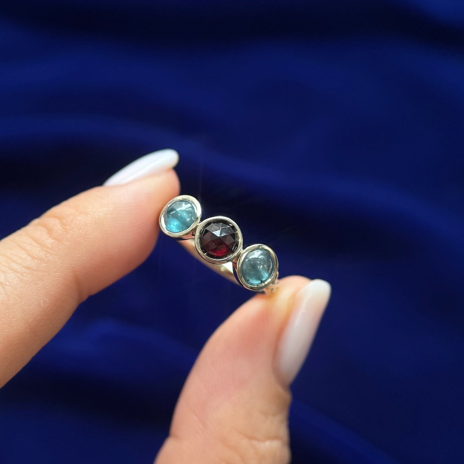 top view of 14k Yellow Gold Bezel-set 5mm Rose-cut Garnet with 2pc 5mm Teal Cabochon Diamonds on a 2.5mm Mix Mirror Band Custom Ring, Size 6