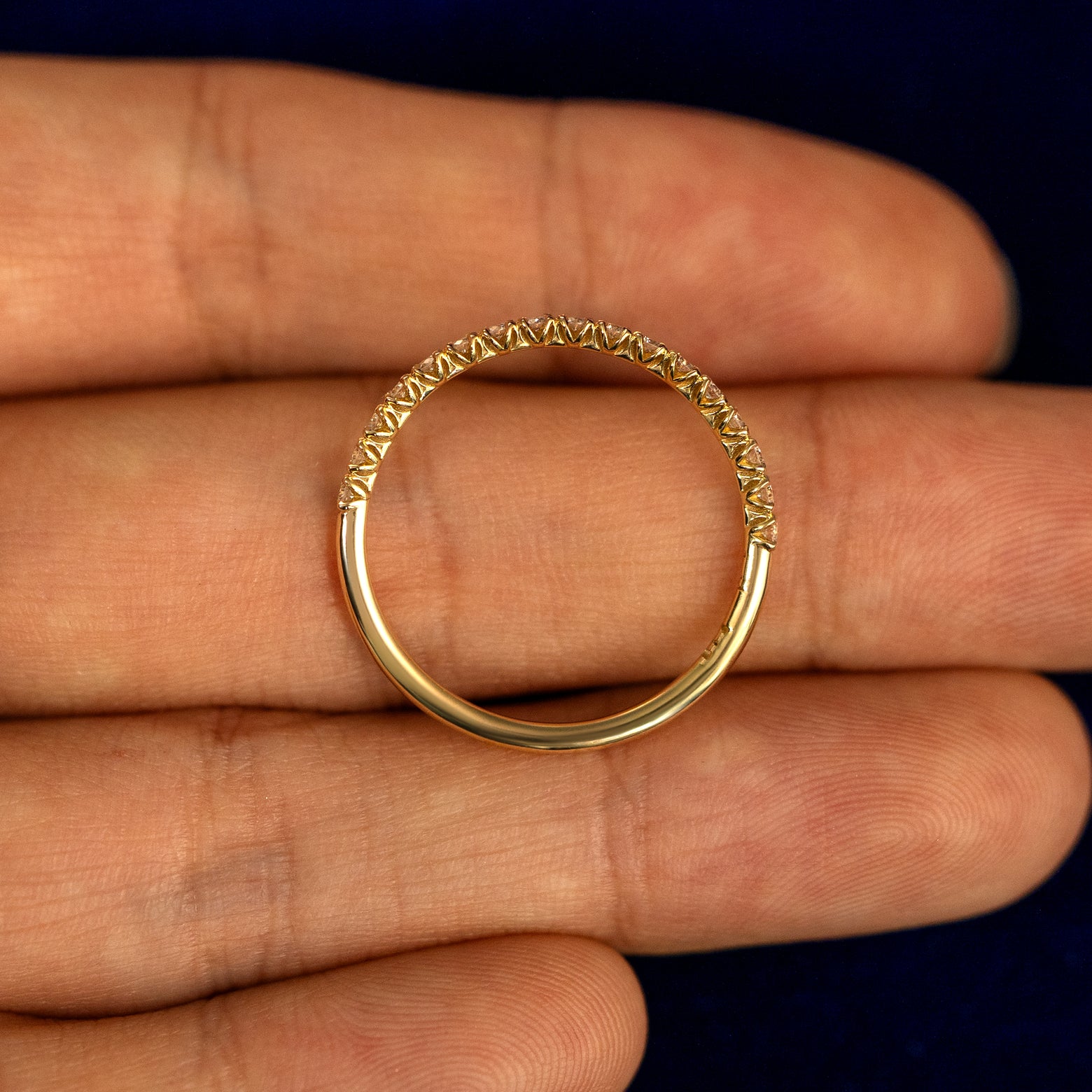 A Mini Petal Set Diamond Eternity Band lying flat in a models hand to show the thickness of the Ring