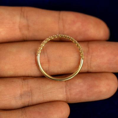 A Mini Petal Set Diamond Eternity Band lying flat in a models hand to show the thickness of the Ring