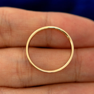 A flush gemstone industrial band laying flat in a models hand to show the thickness of  the band