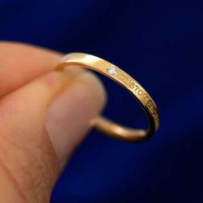 A model holding a flush gemstone industrial band tilted to show the setting of the stone