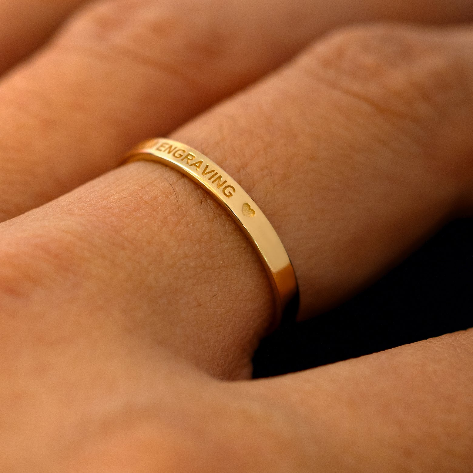 A model wearing a flush gemstone industrial band to show the personalized message with engraved heart on the top of the ring