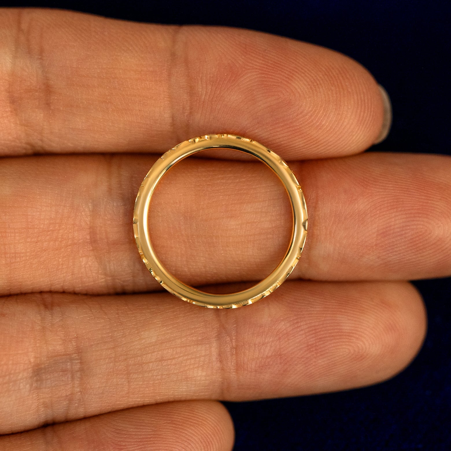 A Thin Filigree Band lying flat in a models hand to show the thickness of the Ring
