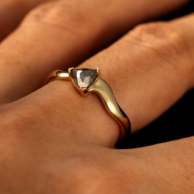 Side view of a solid 14 karat gold Trillion Salt and Pepper Diamond Wavy Ring on a model's finger