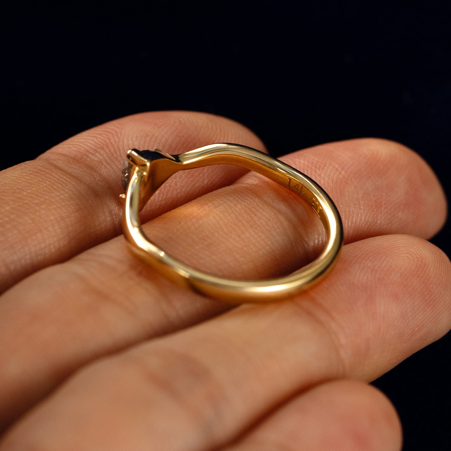 A Trillion Salt and Pepper Diamond Wavy Ring in a model's hand showing the underside of the stones