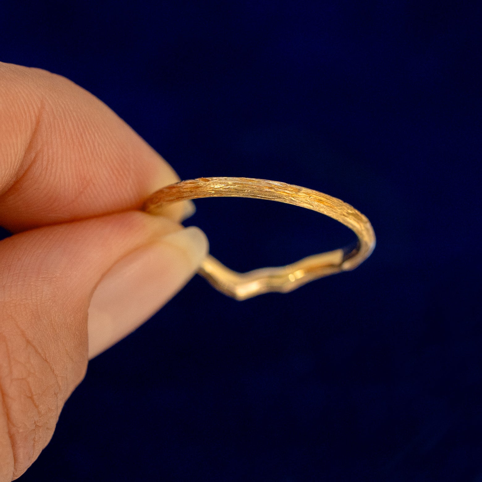 A model holding a Chevron Branches Band backward to show the details of the back of the band