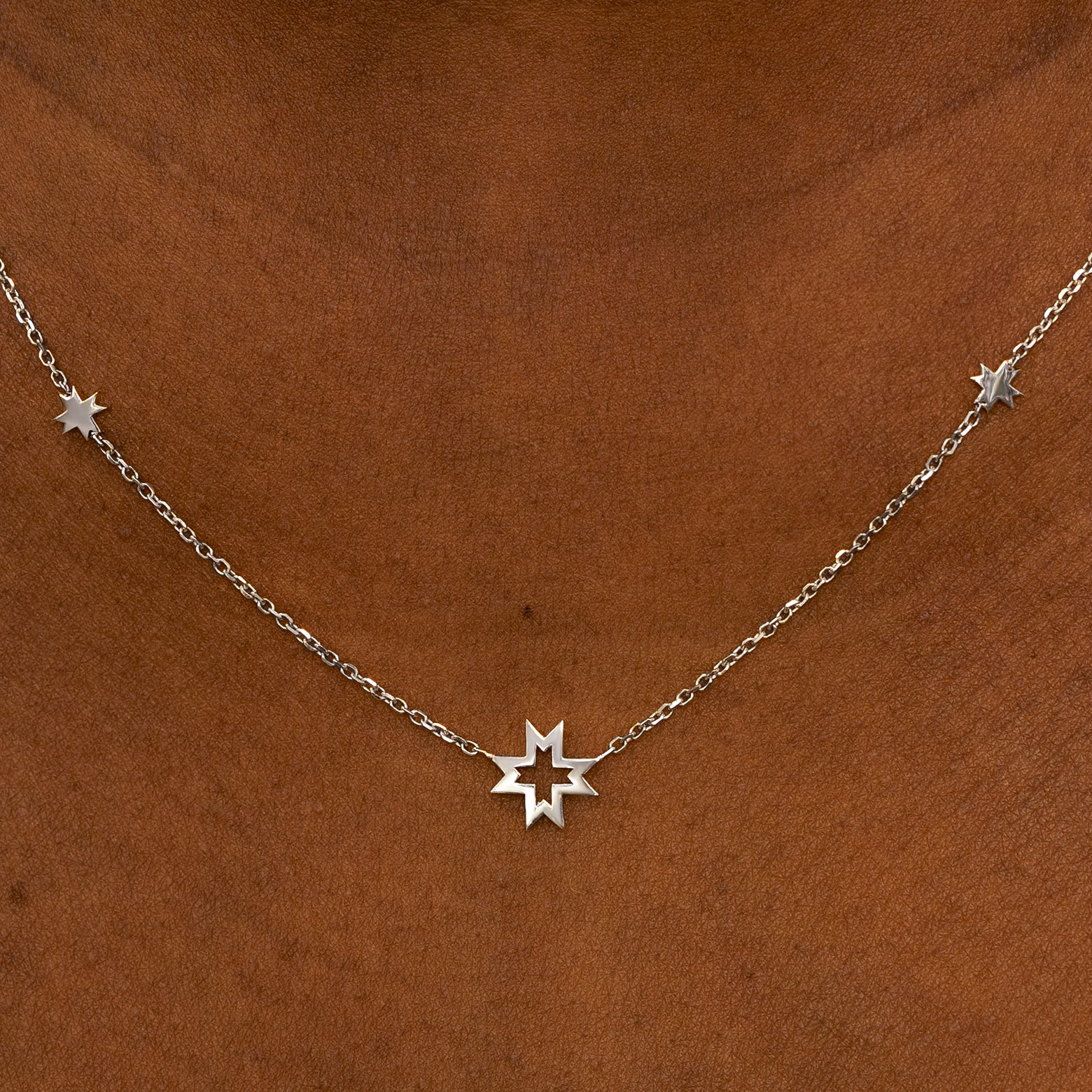 A model wearing a white gold 8 pointed stars station necklace