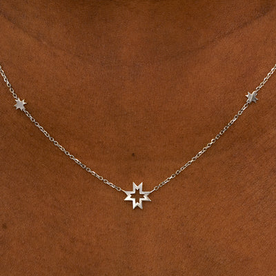 A model wearing a white gold 8 pointed stars station necklace