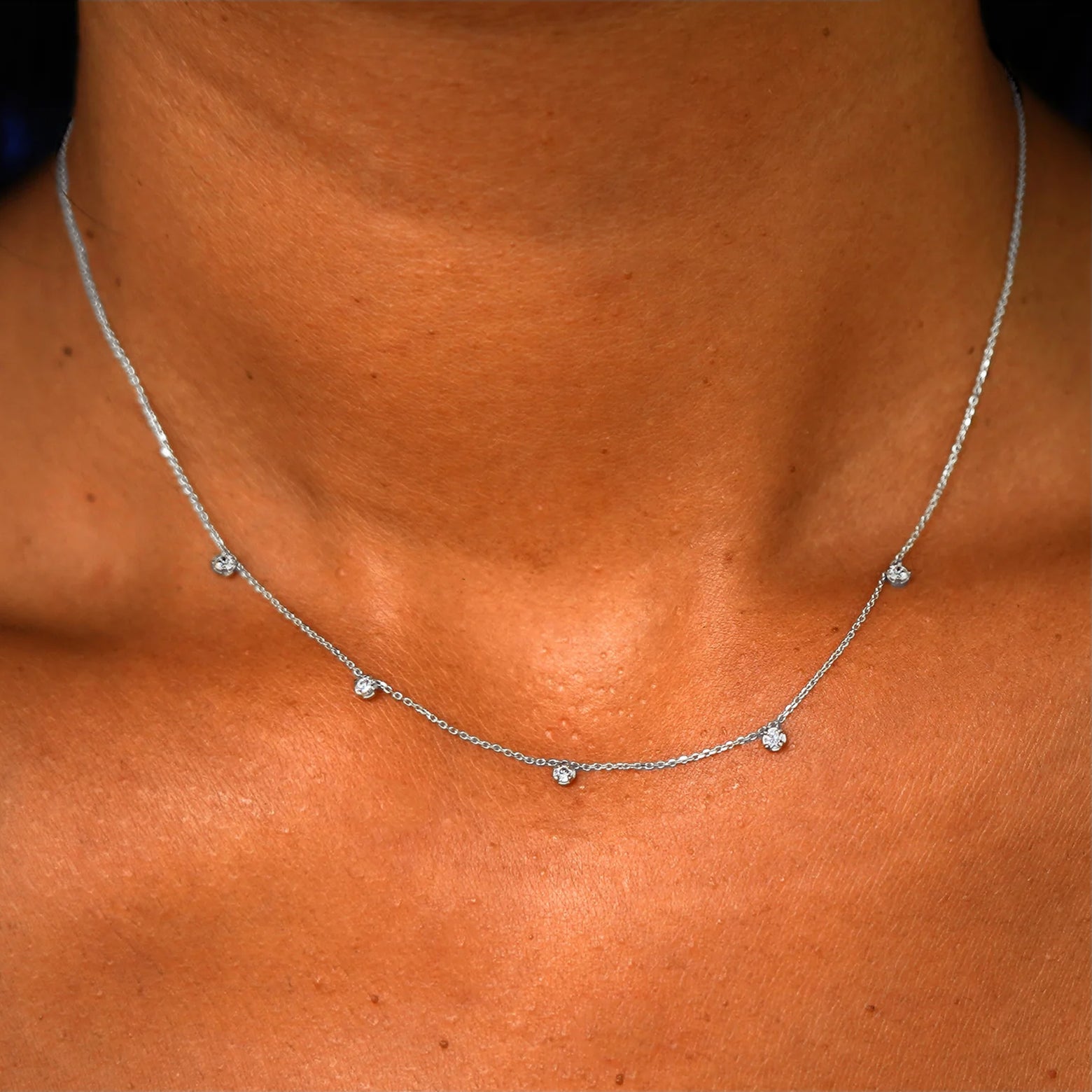 Close up view of a model's neck wearing a solid 14k white gold 5 Diamond Cable Necklace