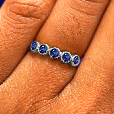 Close up view of a model's hand wearing a white gold 5 Gemstones Ring in sapphires