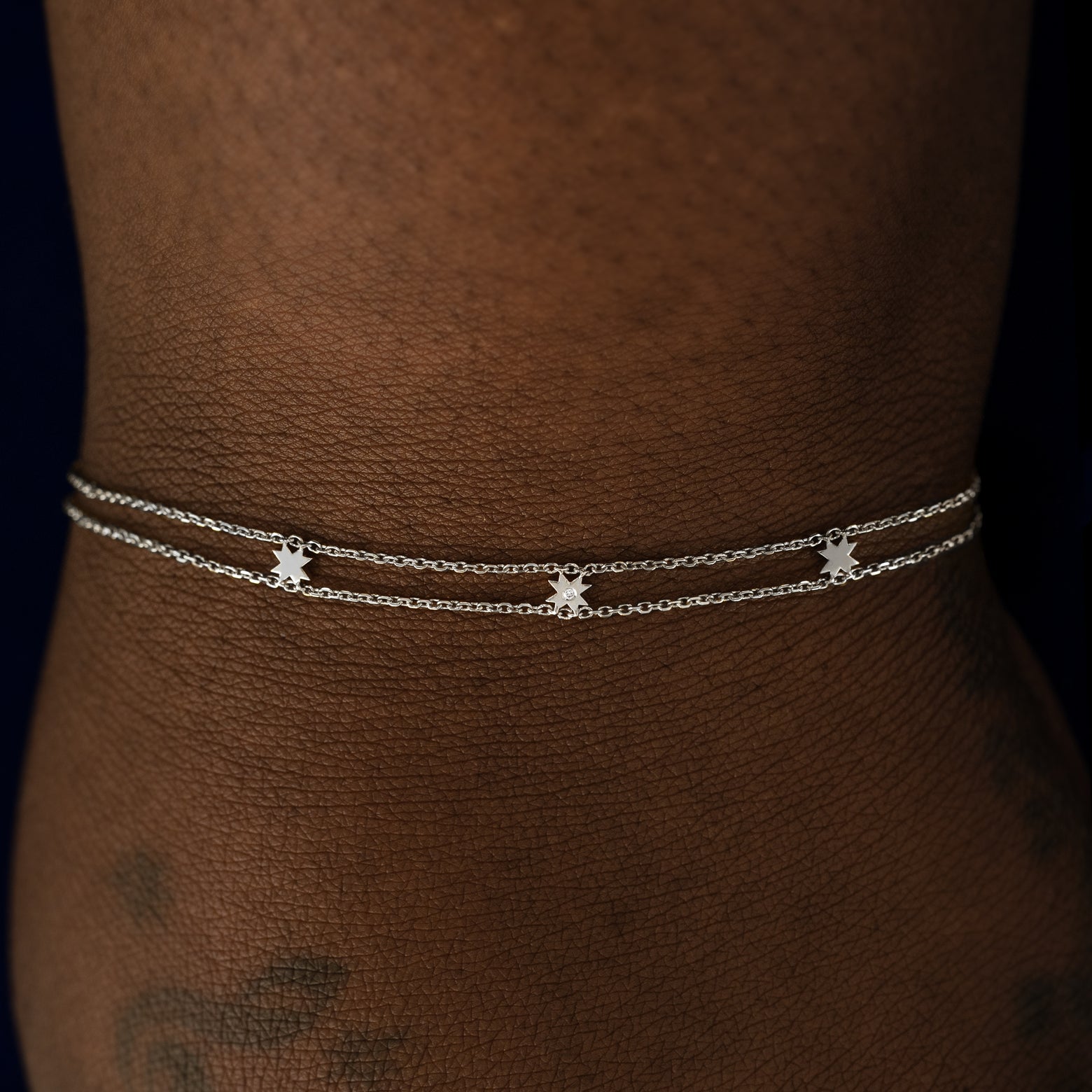 A model wearing a white gold 8 pointed star bracelet