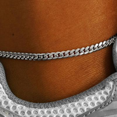 A close up view of model's ankle wear a 14k white gold Medium Miami Anklet