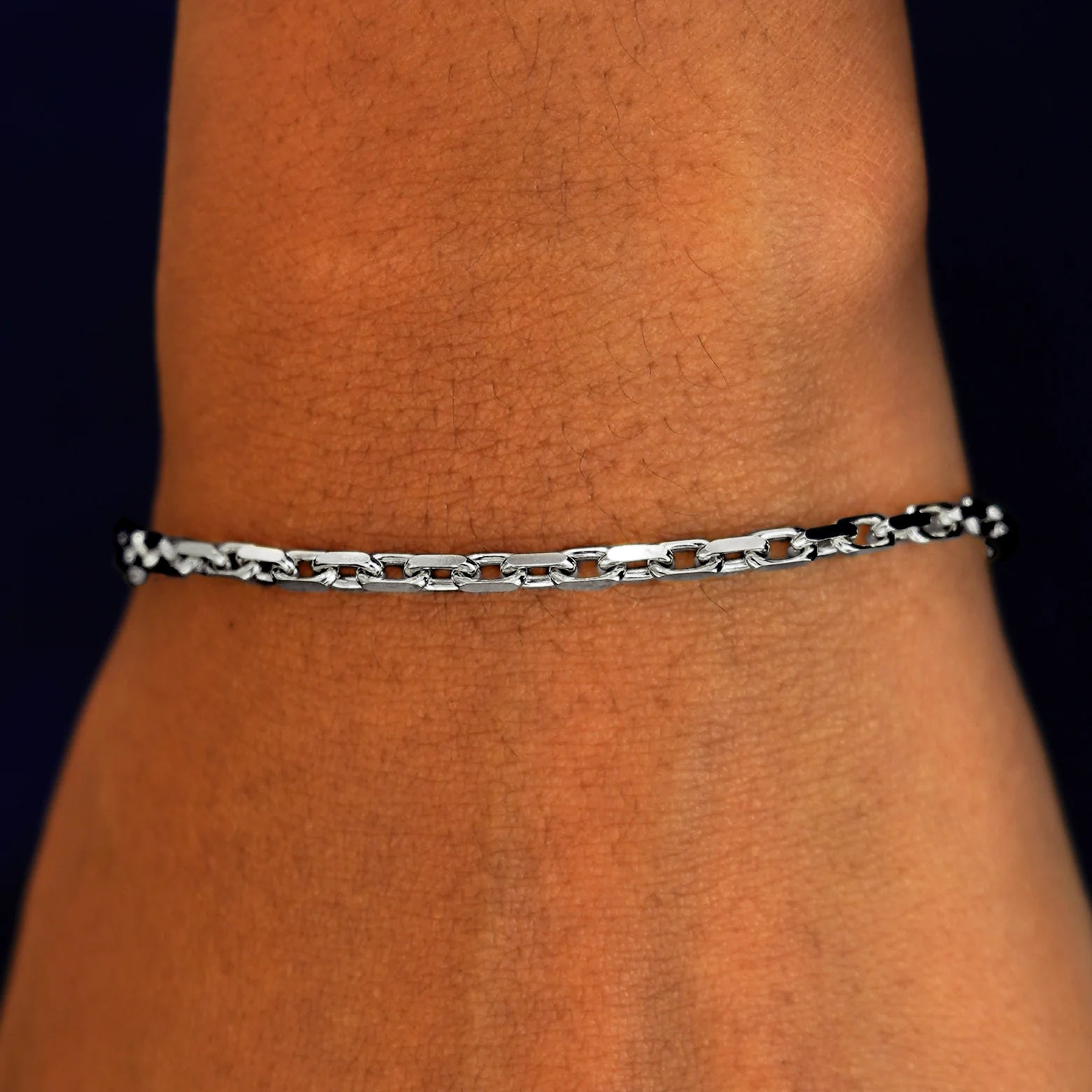 A model's wrist wearing a solid 14k white gold Anchor Bracelet