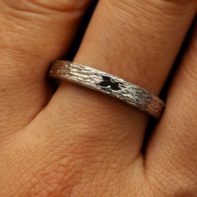 Close up view of a models fingers wearing a 14k white gold baguette diamond raw band