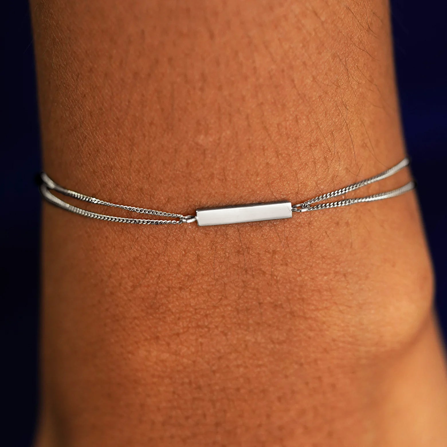 A model's wrist wearing a solid white gold Bar Bracelet