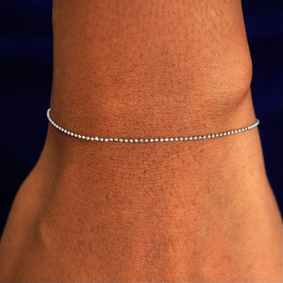 A model's wrist wearing a solid white gold Bead Bracelet