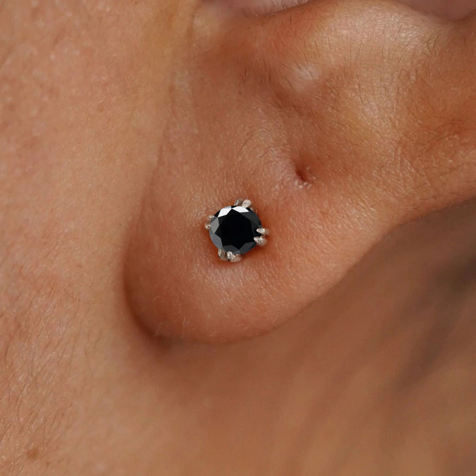 Close up view of a model's ear wearing a 14k white gold Onyx Earring