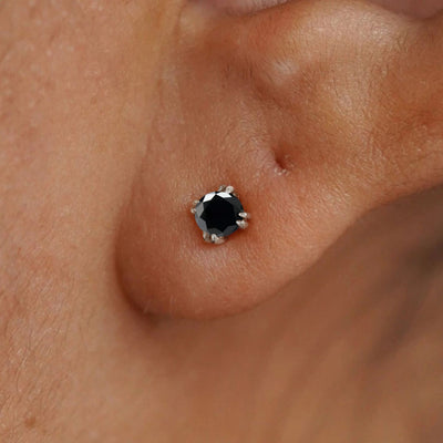 Close up view of a model's ear wearing a 14k white gold Onyx Earring