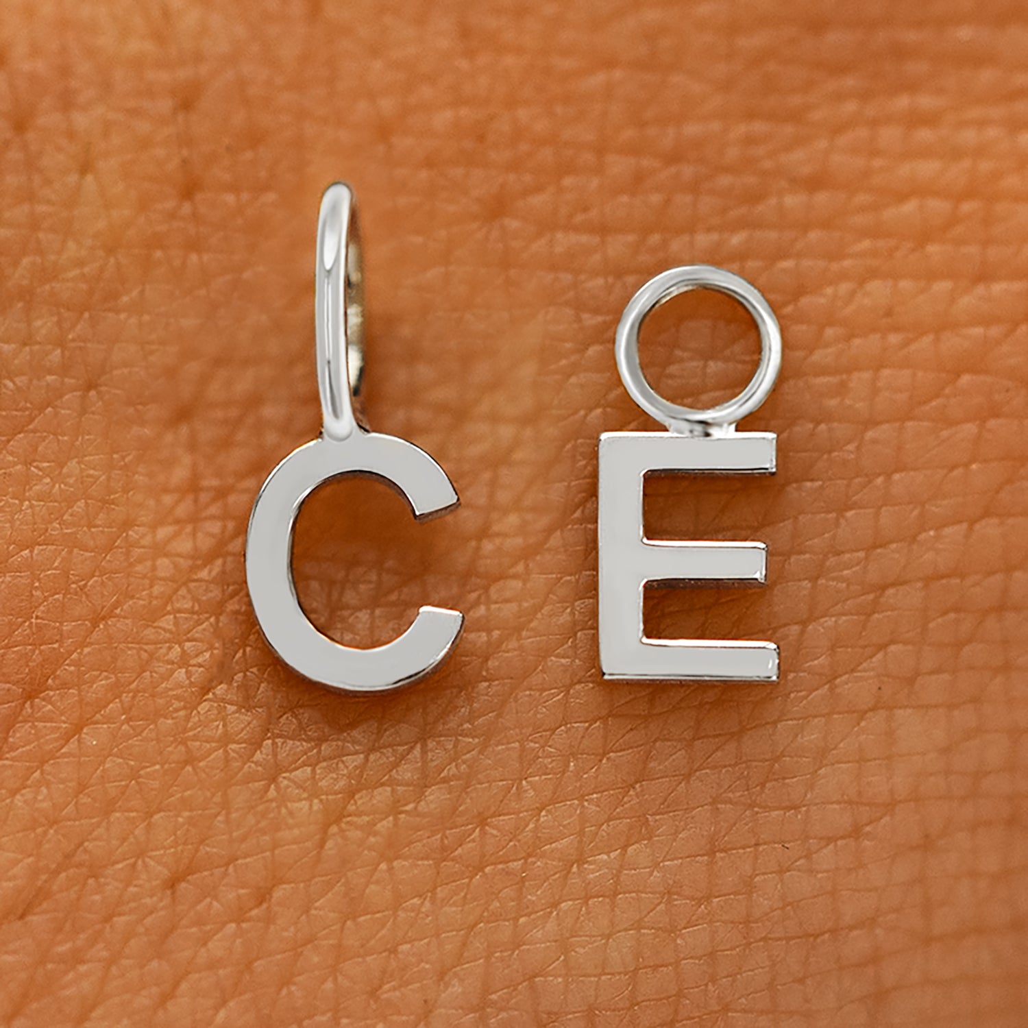 Two versions of the Block Initial Charm in the letters C and E showing For Chain and For Earring options in white gold