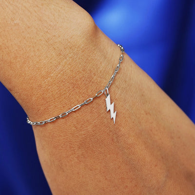 Close up view of a model's wrist wearing a white gold Lightning Bolt Charm on a Butch Chain Bracelet