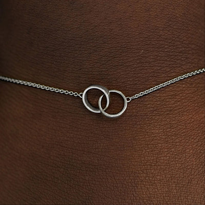 Close up view of a model's wrist wearing a white solid gold Bound Together Bracelet