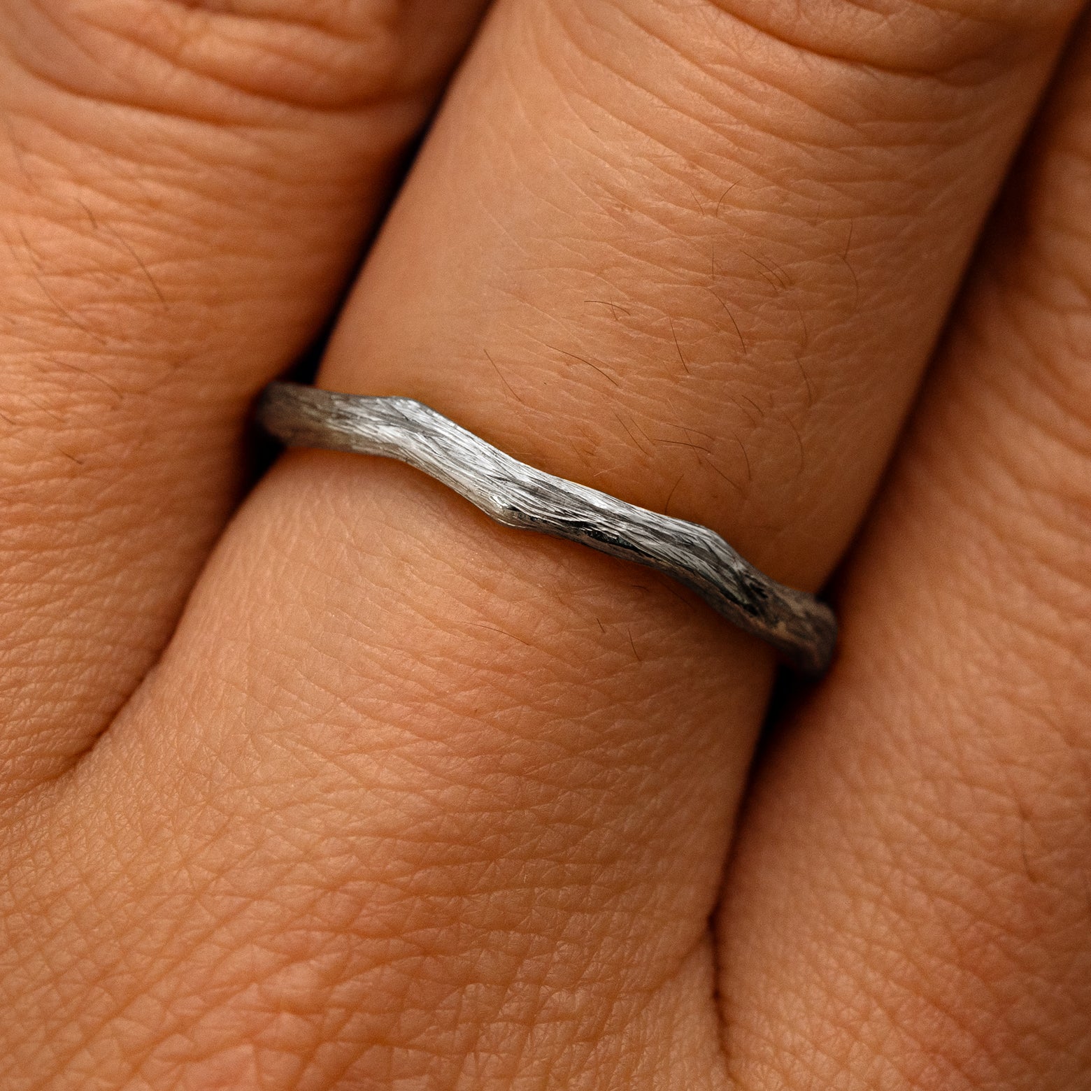 Close up view of a model's fingers wearing a 14k white gold Branch Band
